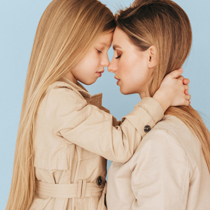 Woman and young girl touch foreheads