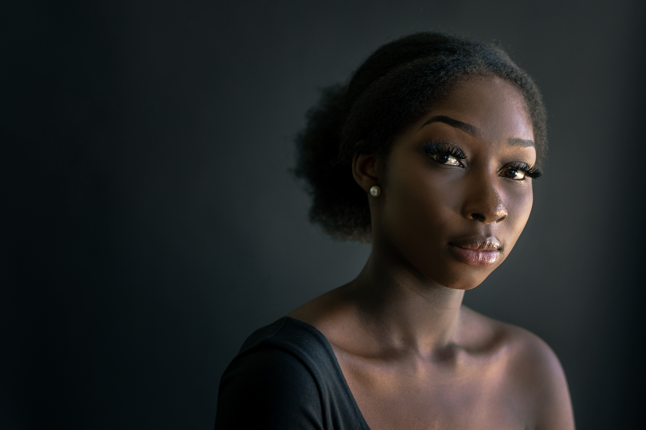 Low-key Portrait of young African Woman, pensive and contemplating her health.