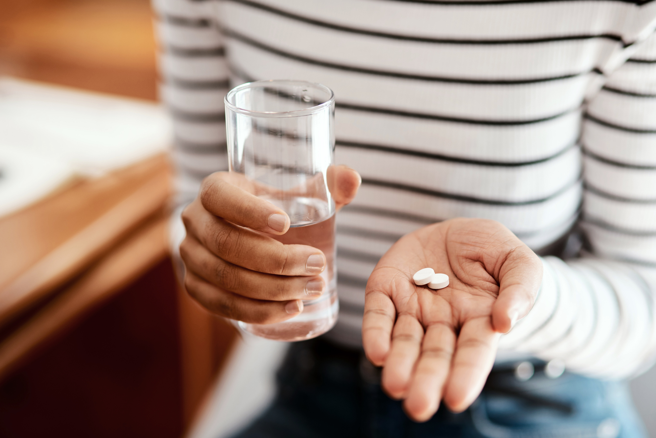 Cropped shot of a woman with fibroids taking her vitamins at home